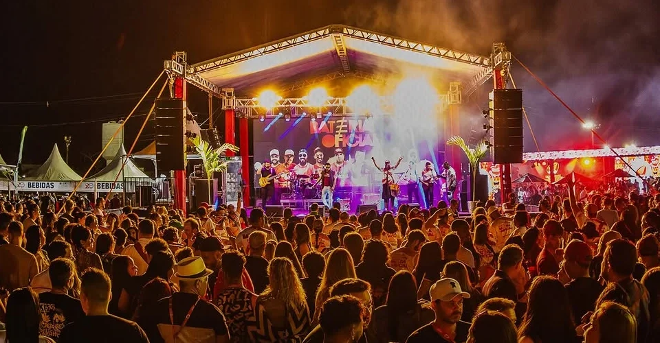 Palco iluminado e público reunido em um show do Prato da Casa